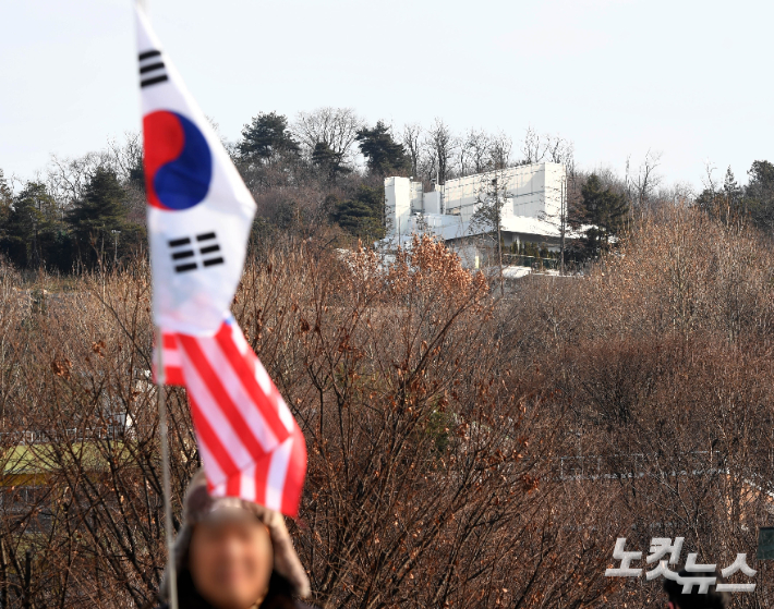 법원이 윤석열 대통령에 대해 고위공직자범죄수사처가 재청구한 내란수괴 혐의 체포영장을 재발부해 유효기간을 연장한 가운데 8일 오전 서울 용산구 한남동 대통령 관저 인근에서 윤 대통령 지지자가 태극기와 성조기를 들고 이동하고 있다. 황진환 기자