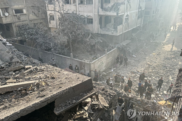 (타스 연합뉴스) 5일(현지시간) 팔레스타인 가자지구의 주민들이 이스라엘군 공습에 무너진 건물 잔해 곁에 서 있다. 2025.1.5 dk@yna.co.kr 연합뉴스