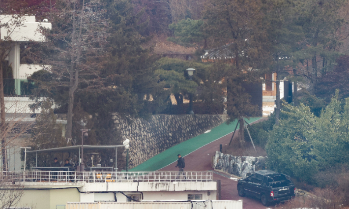 고위공직자범죄수사처(공수처)가 윤석열 대통령에 대한 체포영장을 재발부받은 지 일주일을 맞은 13일 서울 용산구 한남동 대통령 관저에서 경호처 대테러과 소속으로 추정되는 직원이 순찰하고 있다. 연합뉴스