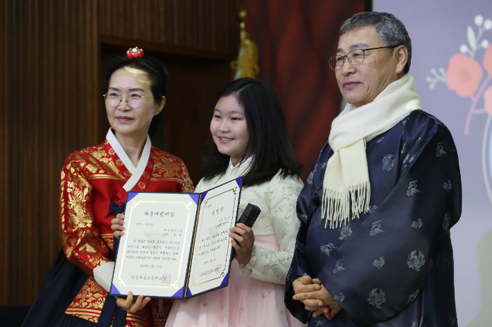 10일 오전 서울 종로구 재동초등학교에서 열린 졸업식에서 한복을 입은 졸업생이 졸업 기념촬영을 하고 있다. 왼쪽부터 성인진 교장선생님, 학생, 정근식 서울시교육감. 연합뉴스
