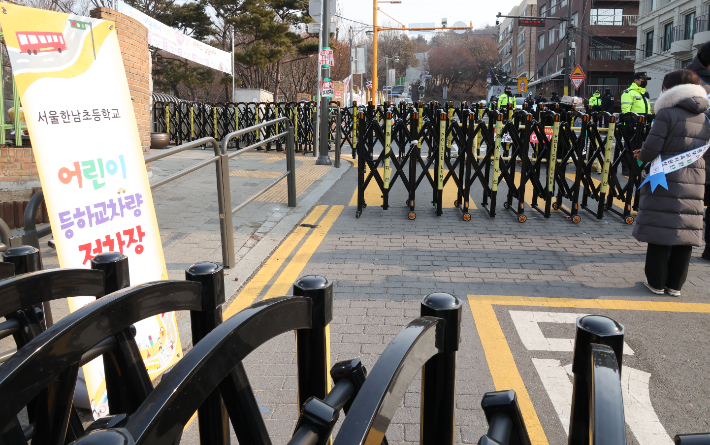 윤석열 대통령 탄핵을 둘러싼 찬반 집회가 연일 이어진 13일 오전 서울 용산구 한남동 한남초등학교 앞에서 통학안전지원단 관계자가 돌봄교실 학생 승하차를 위해 대기해 있다. 연합뉴스