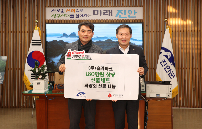전춘성 진안군수가 17일 솔라파크 윤근성 대표(왼쪽)와 설 명절 선물세트 전달식을 마친 뒤 기념촬영을 하고 있다. 진안군 제공