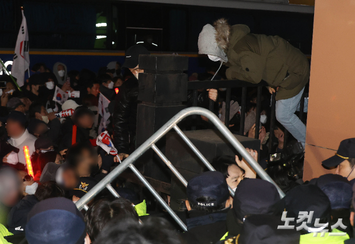 18일 오후 서울 마포구 서울서부지방법원에서 '내란우두머리' 혐의 등으로 체포된 윤석열 대통령의 구속 전 피의자 심문(영장실질심사)이 진행되고 있는 가운데 윤 대통령 지지자들이 법원 담장을 넘고 있다. 황진환 기자