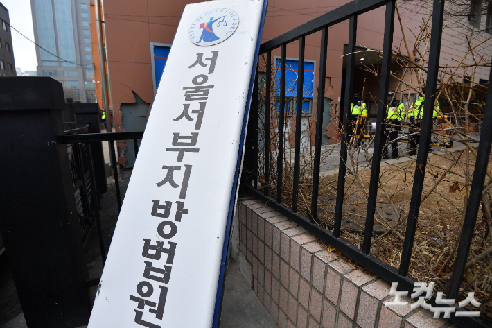 지난 19일 윤석열 대통령에 대한 구속영장이 발부되자 격앙된 지지자들이 서울서부지방법원에 난입해 시설물 등을 파손하며 폭동을 일으킨 가운데 20일 서울 마포구 서울서부지방법원에 쓰러진 현판이 놓여 있다. 류영주 기자