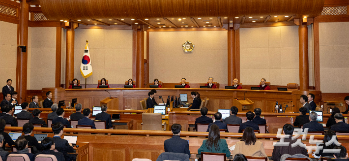 윤석열 대통령이 21일 오후 서울 종로구 헌법재판소 대심판정에서 열린 윤 대통령 탄핵심판 3차 변론기일에 참석했다. 이날 헌법재판관들이 입장하자 참석자들이 기립 후 착석하고 있다. 사진공동취재단