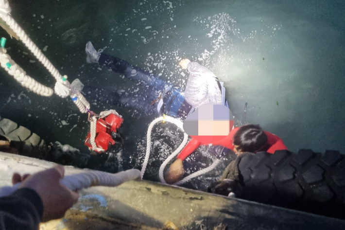 부산해경이 22일 부산 서구 남항 통선부두 바다에서 익수자를 구조하고 있다. 부산해양경찰서 제공