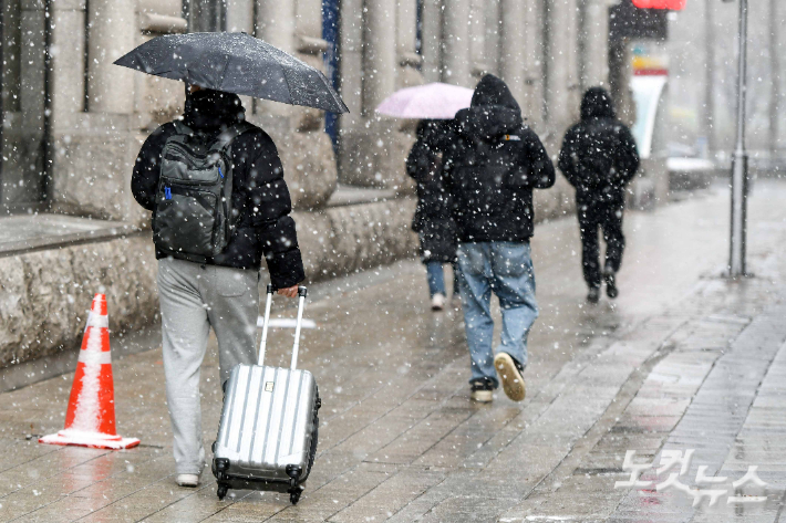 설연휴 임시공휴일인 27일 서울 도심에 눈이 내리고 있다. 임시공휴일인 27일부터 28일까지 이틀간에만 강원내륙과 전북동부에 최대 30㎝, 수도권에 최대 25㎝ 이상의 폭설이 예보됐다. 설연휴 고향을 오가는 귀성·귀경길 빙판길 사고 위험이 높아질 것으로 예상돼 교통안전에 각별한 주의가 요구된다. 박종민 기자