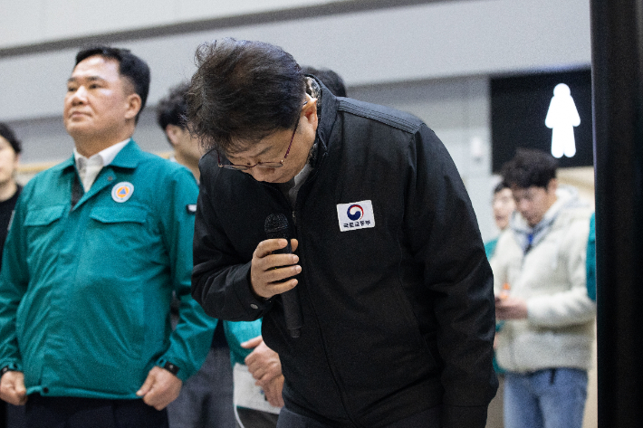 박상우 국토교통부 장관이 제주항공 참사가 벌어진 지난달 29일 저녁 무안공항을 찾아 피해자 가족들에게 고개숙여 사과하고 있다. 왼쪽은 교통 분야를 담당하는 백원국 2차관. 국토교통부 제공