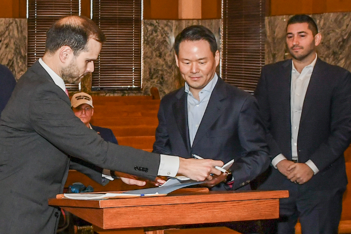 지난 달 27일(현지시각) 미국 텍사스주 존슨 카운티(Johnson County) 지방법원에서 진행된 파리바게뜨 제빵공장 투자 인센티브 조인식에서 허진수 SPC그룹 사장이(가운데) 서명을 하고 있다. SPC그룹 제공