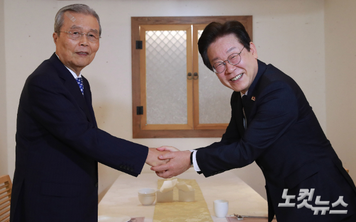 이재명 더불어민주당 대표와 김종인 전 국민의힘 비상대책위원장이 지난해 9월 12일 서울 종로구 광화문의 한 식당에서 회동, 악수하고 있다. 윤창원 기자
