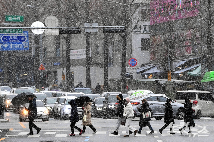 서울 전역에 대설주의보가 내려진 6일 오후 서울 강서구 화곡역 인근에서 시민들이 눈을 맞으며 걷고 있다. 황진환 기자