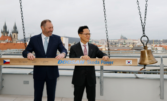 두산에너빌리티 박상현 사장(오른쪽)과 프라하 증권거래소 페트르 코블리츠 CEO가 증시 상장을 알리는 종을 울리고 있다. 두산에너빌리티 제공