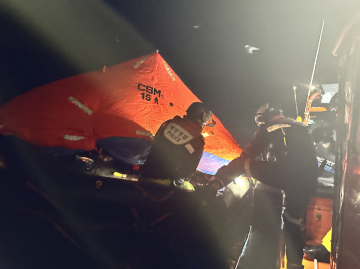 해경대원들이 구명뗏목에서 선원들을 구조하고 있다. 여수해경 제공