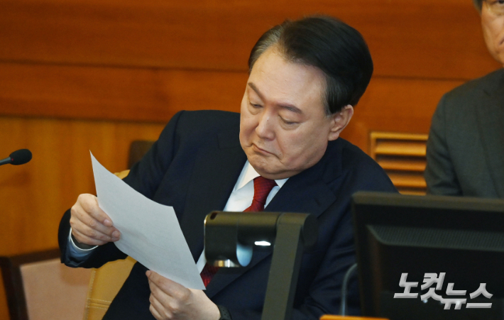 윤석열 대통령이 6일 오전 서울 종로구 헌법재판소 대심판정에서 열린 탄핵심판 6차 변론기일에 출석, 자료를 보고 있다. 사진공동취재단