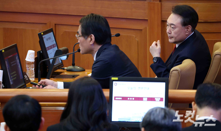 윤석열 대통령이 11일 서울 종로구 헌법재판소에서 열린 탄핵심판 7차 변론기일에 출석해 변호인과 대화하고 있다. 사진공동취재단