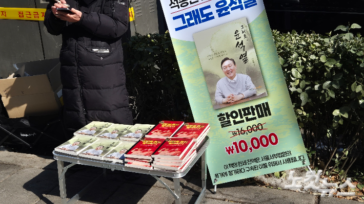 11일 윤석열 대통령의 탄핵 무효를 요구하는 집회가 열리는 서울 종로구 안국역 인근에서 윤 대통령의 변호인인 석동현 변호사가 저술한 책 '그래도 윤석열'이 판매되고 있다. 주보배 기자