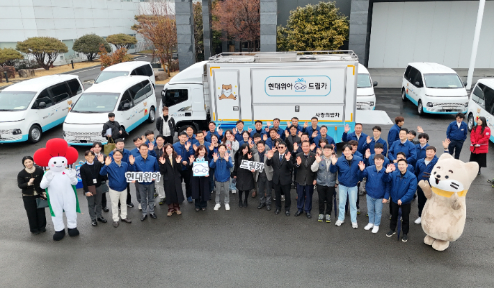 현대위아 직원과 복지기관 관계자들이 12일 경남 창원 현대위아 본사에서 열린 '드림카 기증식'에서 기념사진을 찍고 있다. 현대위아 제공