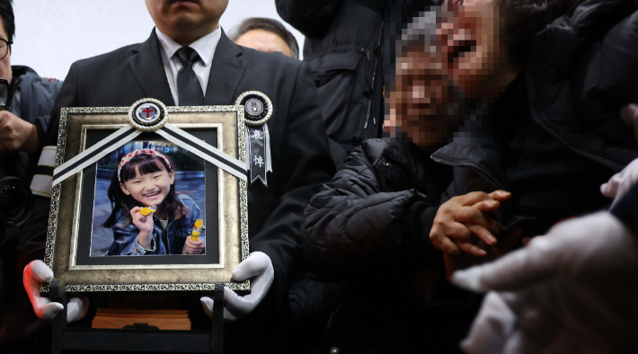 학교에서 교사에게 살해된 8살 김하늘 양이 14일 영면에 들어갔다. 하늘이 영정 사진을 앞세운 유가족들이 빈소를 나서고 있다. 연합뉴스