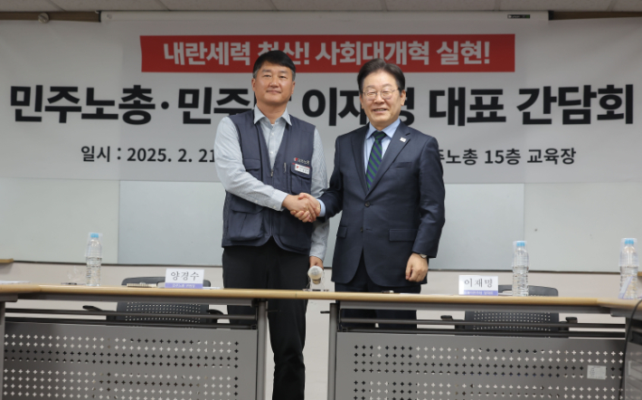 더불어민주당 이재명 대표와 전국민주노동조합총연맹 양경수 위원장이 21일 서울 중구 민주노총 사무실에서 열린 민주당-민주노총 간담회에서 악수를 나누고 있다. 연합뉴스