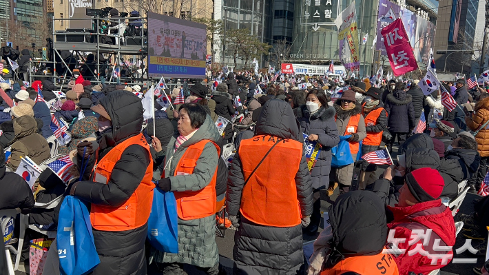 22일 계엄합법·탄핵반대 국민대회 시작 전 사랑제일교회 성도들이 집회 참여자들로부터 헌금을 걷고 있다. 박인 기자