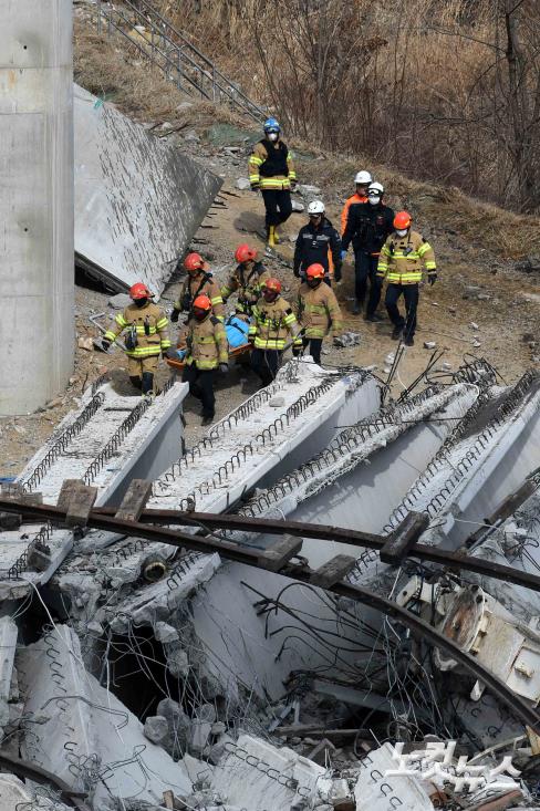 구조물 붕과 사고 사상자 옮기는 소방대원들