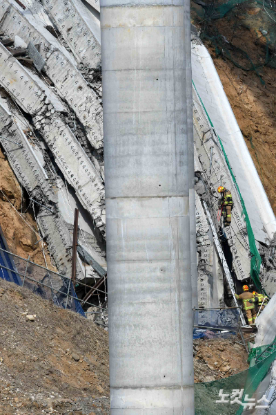 25일 구조물 붕괴 사고가 발생한 경기 안성 서운면 산평리 인근 고속도로 공사 현장에서 소방대원들이 수습한 시신을 운구하고 있다. 안성=박종민 기자