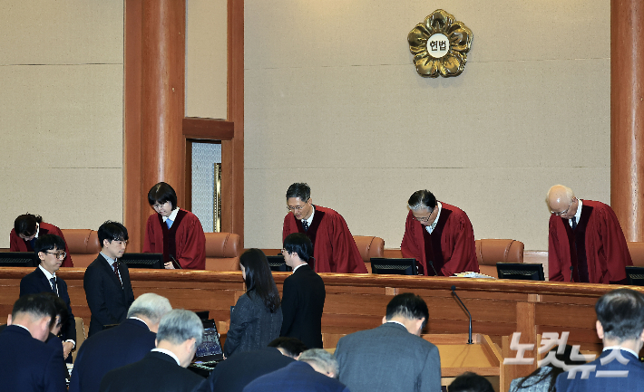 문형배 헌법재판소장 권한대행과 헌법재판관 등이 25일 오후 서울시 종로구 재동 헌법재판소 대심판정에서 열린 대통령 탄핵 심판 11차 변론에 참석해 인사하며 자리에 앉고 있다. 사진공동취재단
