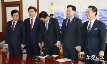 우원식(가운데) 국회의장이 26일 오전 서울 여의도 국회에서 여야 원내대표 회동을 주재하며 양당 원내대표의 손을 잡고 있다. 왼쪽부터 박형수 국민의힘 원내수석부대표, 권성동 원내대표, 우 의장, 박찬대 더불어민주당 원내대표, 박성준 원내수석부대표.