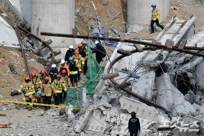 지난 25일 구조물 붕괴 사고가 발생한 경기 안성 서운면 산평리 인근 고속도로 공사 현장에서 소방대원들이 수습한 시신을 운구하고 있다. 안성=박종민 기자