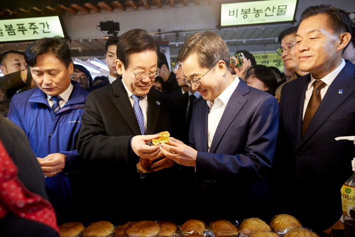 지난해 11월 이재명 대표와 김동연 지사가 경기 수원시 내 전통시장 민생탐방에서 빵을 나눠 먹고 있다. 경기도 제공