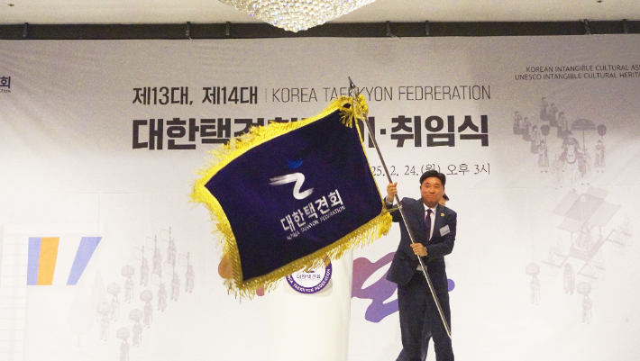 오성문 대한택견회장이 취임식에서 택견회 단체기를 들어 보이고 있다. 대한택견회 제공