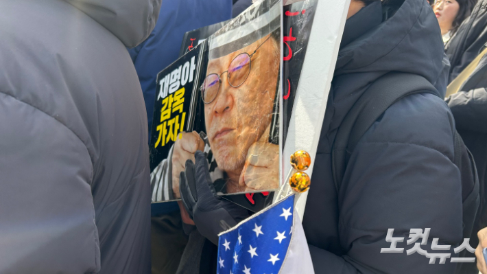 3일 서울 동작구 중앙대학교 정문 앞에서 윤 대통령 지지자가 이재명 대표 얼굴 손팻말을 들고 집회에 참석하고 있다. 박인 기자