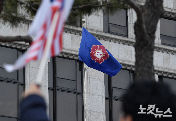 윤석열 대통령 탄핵심판 마지막 변론기일인 25일 서울 종로구 헌법재판소에서 헌재 깃발이 펄럭이는 가운데 윤 대통령 지지자들의 피켓이 보이고 있다. 류영주 기자