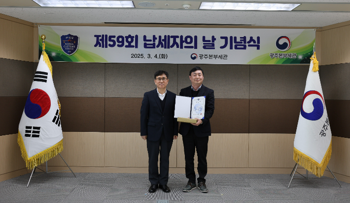 금호타이어 김경훈 책임(사진 오른쪽)이 제59회 납세자의 날 기념식에서 세정협조자에 선정돼 기재부 장관 표창을 받고 김동수 광주본부세관장과 기념사진을 찍고 있다. 금호타이어 제공