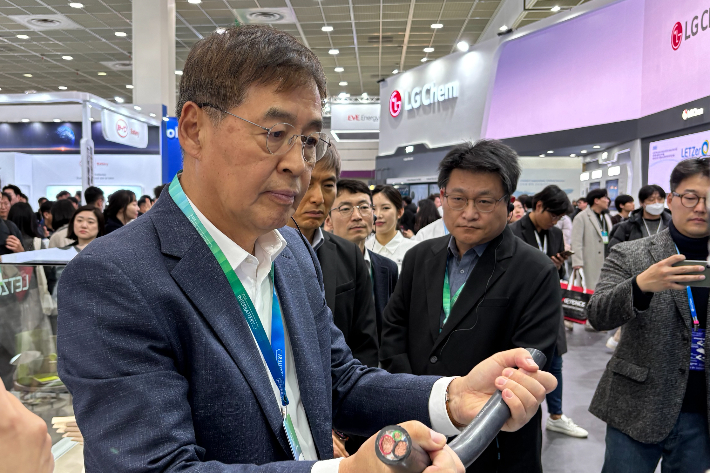 신학철 LG화학 부회장이 6일 서울 강남구 코엑스에서 이틀째 열리고 있는 '인터배터리 2025'의 LG화학 부스를 찾아 초고중합도 PVC로 만든 전기차 충전용 케이블을 보고 있다. LG화학 제공