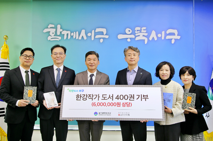 광주서구청에서 6일 열린 한강 작가 도서 전달식에 김이강 서구청장과 이동훈 광주신세계 대표이사 등 관계자들이 기념사진을 찍고 있다. 광주신세계 제공