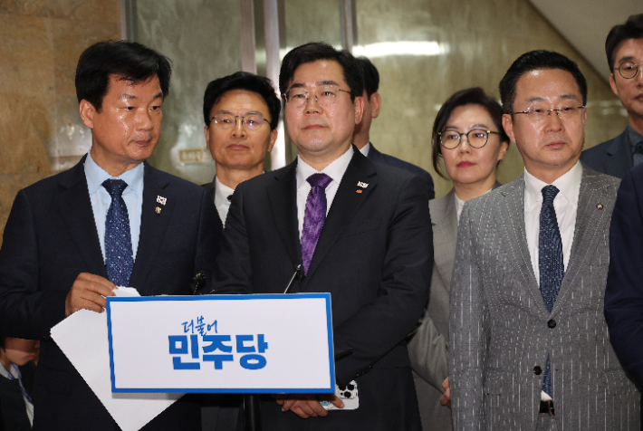 법원이 윤석열 대통령의 구속 취소 청구를 받아들인 7일 서울 여의도 국회에서 더불어민주당 박찬대 원내대표와 의원들이 긴급 의원총회 도중 잠시 나와 취재진의 질문을 받고 있다. 연합뉴스