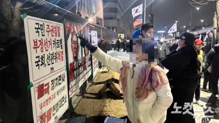 서울 용산구 한남동 대통령 관저 앞에서 헌법재판소 재판관을 가리키며 욕설을 뱉고 있는 윤 대통령 지지자. 박인 기자