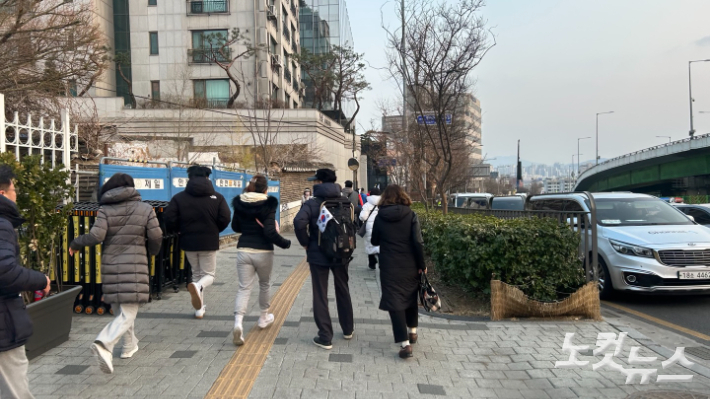 8일 윤석열 대통령 석방 소식을 듣고 관저 입구 앞으로 뛰어가는 지지자들. 박인 기자