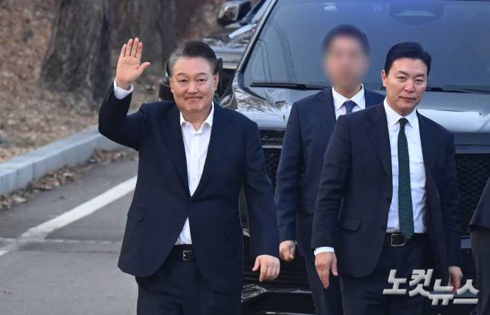 법원의 구속 취소 결정에 검찰이 항고를 포기하면서 석방된 윤석열 대통령이 8일 오후 경기 의왕 서울구치소에서 나와 지지자들에게 인사를 하고 있다. 오른쪽은 김성훈 경호처 차장. 의왕=황진환 기자