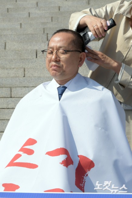 더불어민주당 김문수 의원이 박홍배·전진숙 의원과 11일 서울 여의도 국회 본청 앞에서 윤석열 대통령 조기 파면을 촉구하는 삭발식하고 있다.