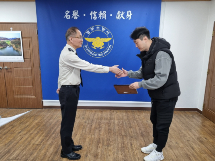 송인수 경주소방서장이 화재 발생 차량의 운전자를 구조한 화물차 운전기사 김종현 씨에게 표창장을 수여하고 있다. 경주소방서 제공