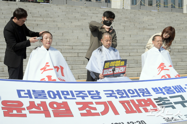 더불어민주당 박홍배·김문수·전진숙 의원이 11일 서울 여의도 국회 본청 앞에서 윤석열 대통령 조기 파면을 촉구하는 삭발식을 하고 있다. 윤창원 기자