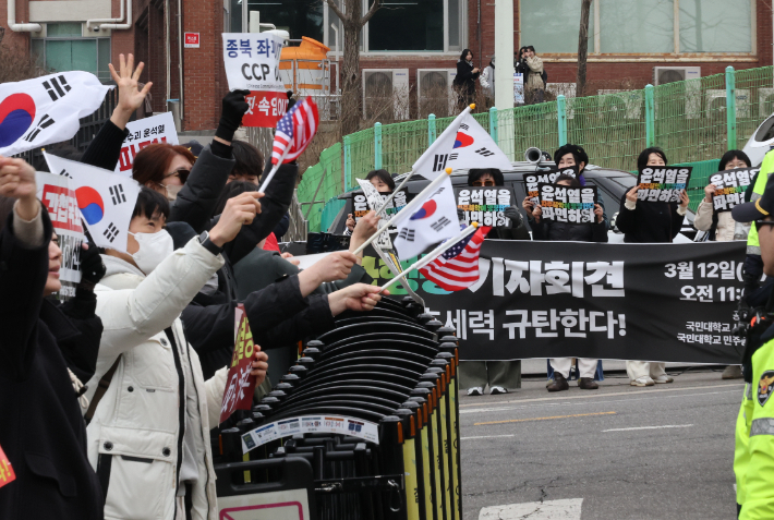 12일 서울 국민대학교 정문 앞에서 윤석열 대통령 파면을 촉구하는 국민대학교 민주동문회 소속 동문 및 학생들과 탄핵 반대를 주장하는 보수단체 회원들이 집회를 하고 있다. 연합뉴스