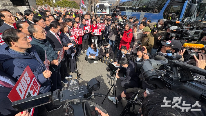 헌법재판소가 13일 오전 최재해 감사원장과 검사 3인에 대한 탄핵심판 선고기일을 열고 재판관 전원일치 의견으로 탄핵소추 기각을 결정하자 국민의힘 의원들이 헌재 앞에 모여 더불어민주당을 규탄하는 포스터를 들었다. 김수정 수습기자