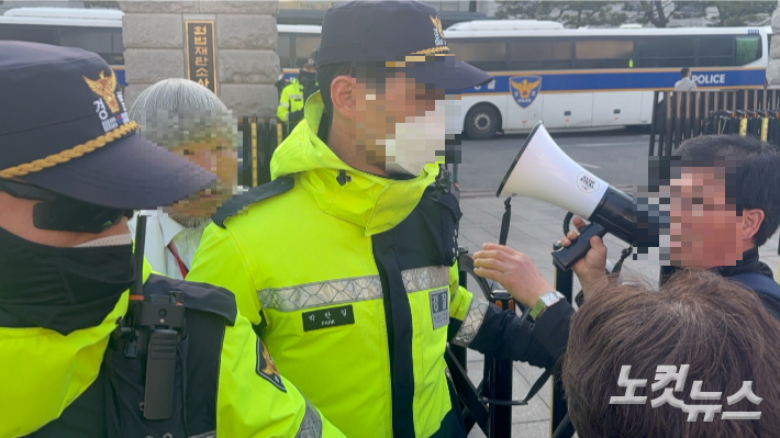13일 서울 종로구 헌법재판소 앞에서 경찰 기동대원을 향해 확성기를 이용해 소리 지르는 집회 참가자. 김수정 수습기자