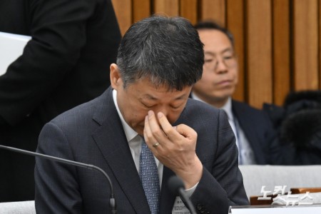 김광일 홈플러스 대표이사 겸 MBK 부회장이 18일 국회에서 열린 정무위원회 홈플러스 기업회생절차에 대한 현안 질의에서 얼굴을 만지고 있다.