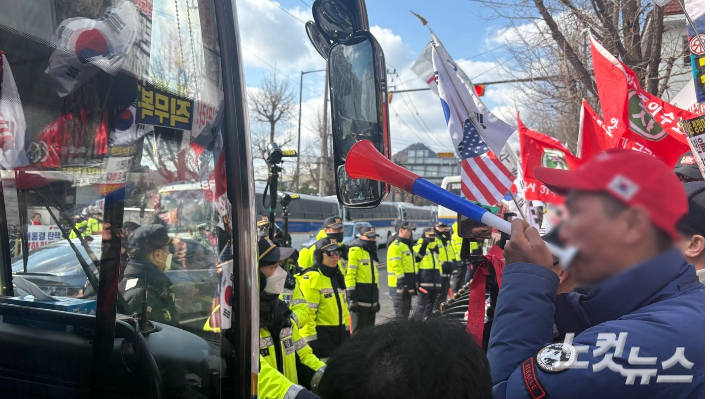 지난 18일 서울 종로구 헌법재판소 맞은편에서 바리케이드 사이로 경찰 기동대원과 지지자들이 대치하고 있는 모습. 김수정 수습기자