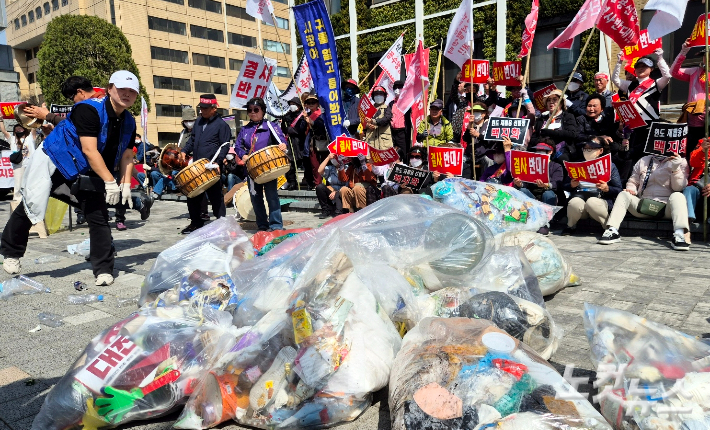 청주시 현도면 주민들이 26일 충북도청 앞에서 집회를 열고 현도일반산업단지계획 변경 신청 불허를 촉구하며 쓰레기를 던지는 퍼포먼스를 진행하고 있다. 최범규 기자