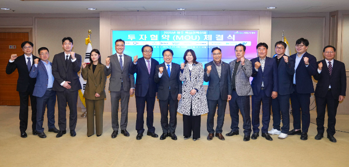 강기정 광주광역시장이 27일 오후 시청 비즈니스룸에서 열린 '2025 광주 핵심전략산업투자협약 체결식'에 참석해 협약서에 서명을 한 뒤 기념촬영을 하고 있다. 광주광역시 제공